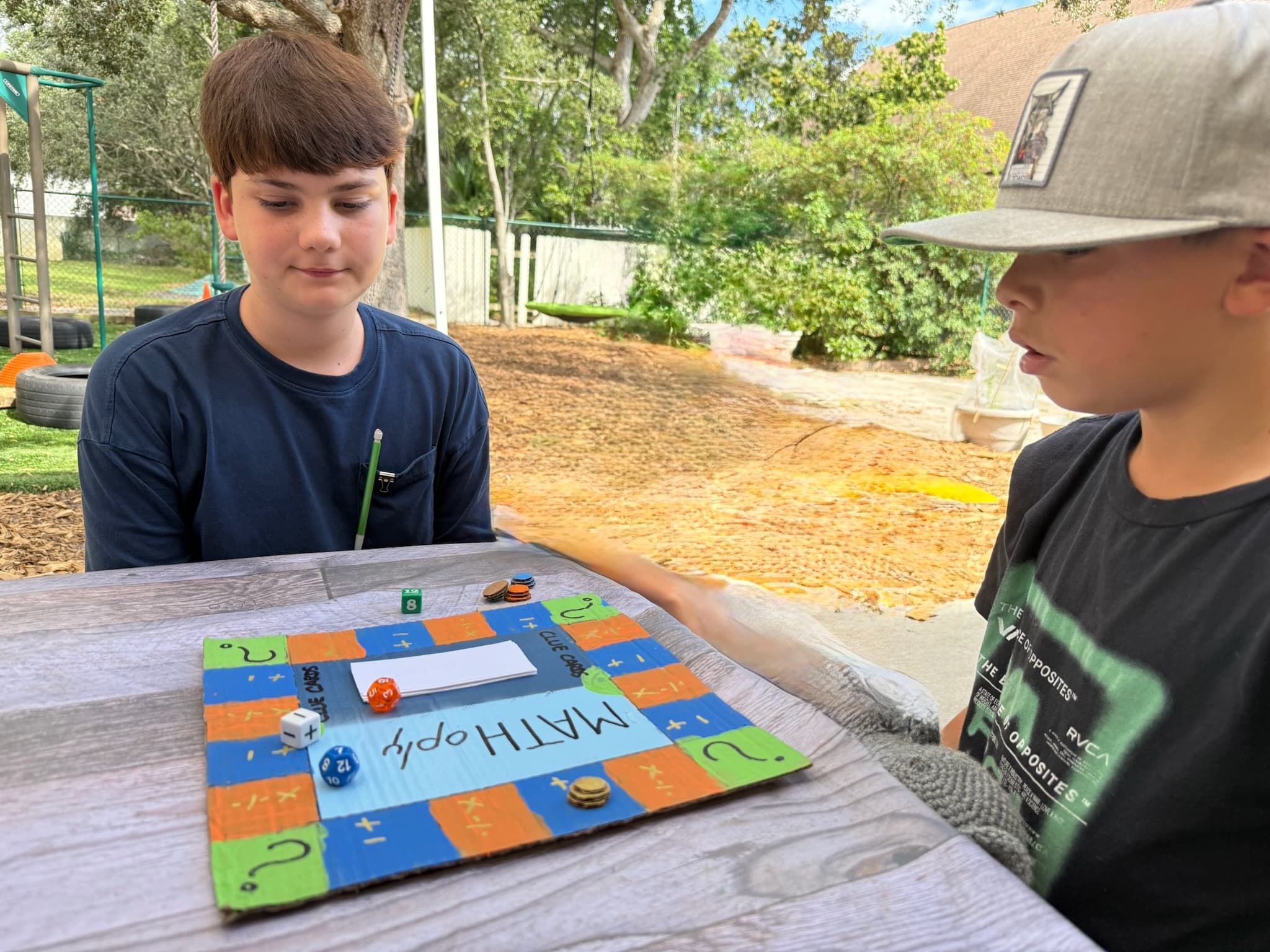 Two Oaks students focused on a game of Math-opoly at The Grow Co-op
