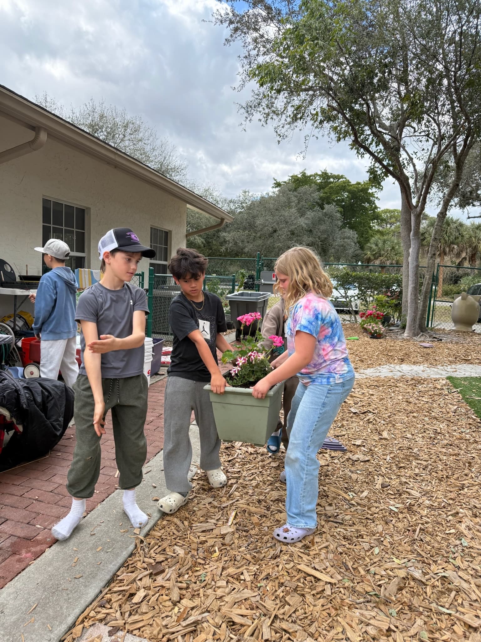 GROW students carrying a planter box to the garden